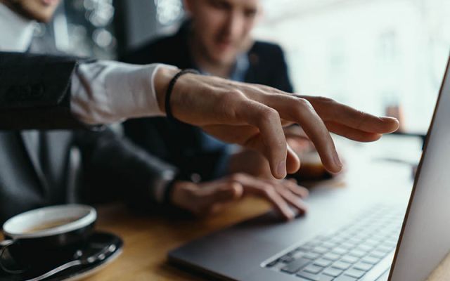 businessmen pointing laptop screen